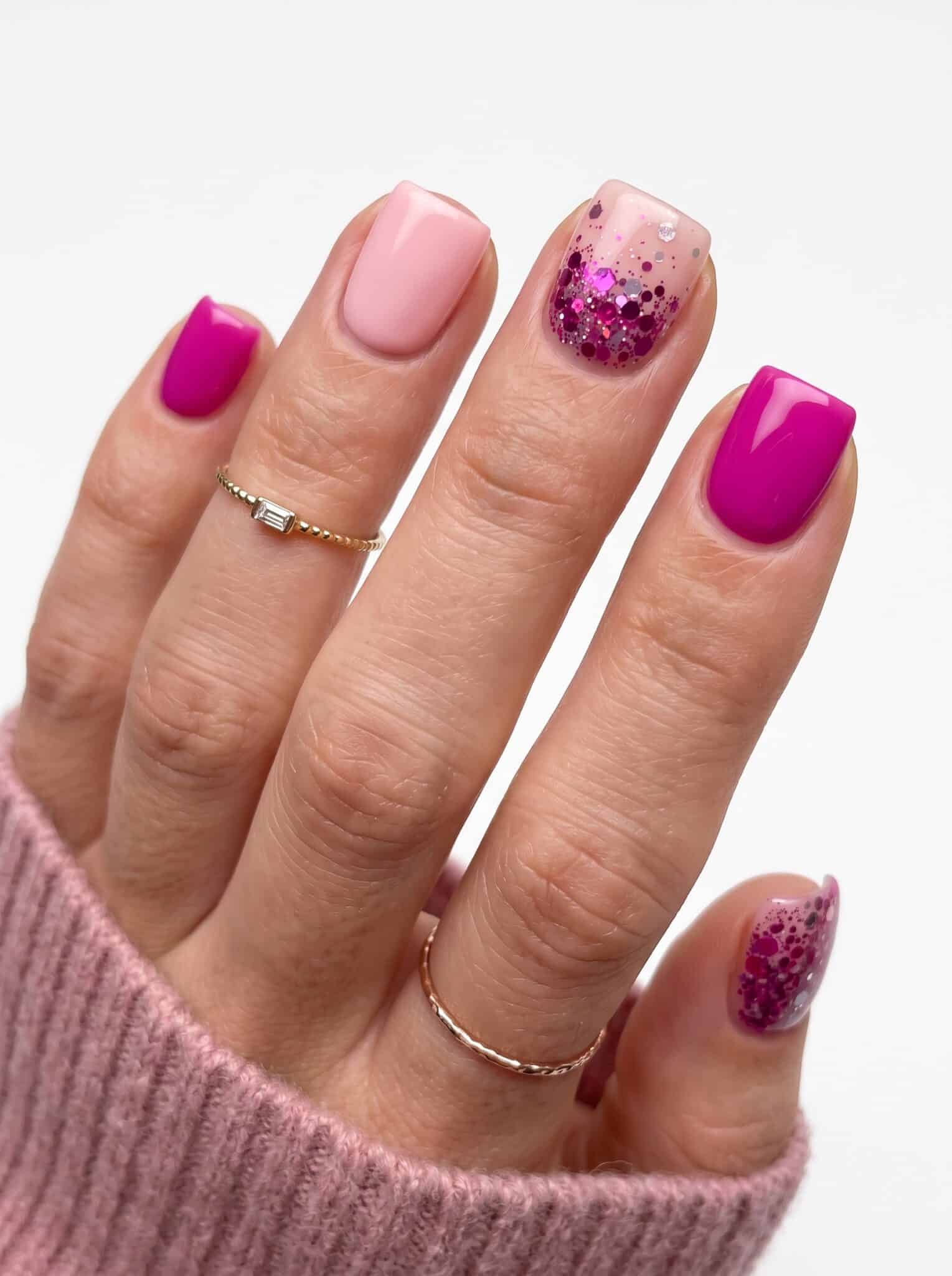 Hot pink gel nails with thin silver and gold rings