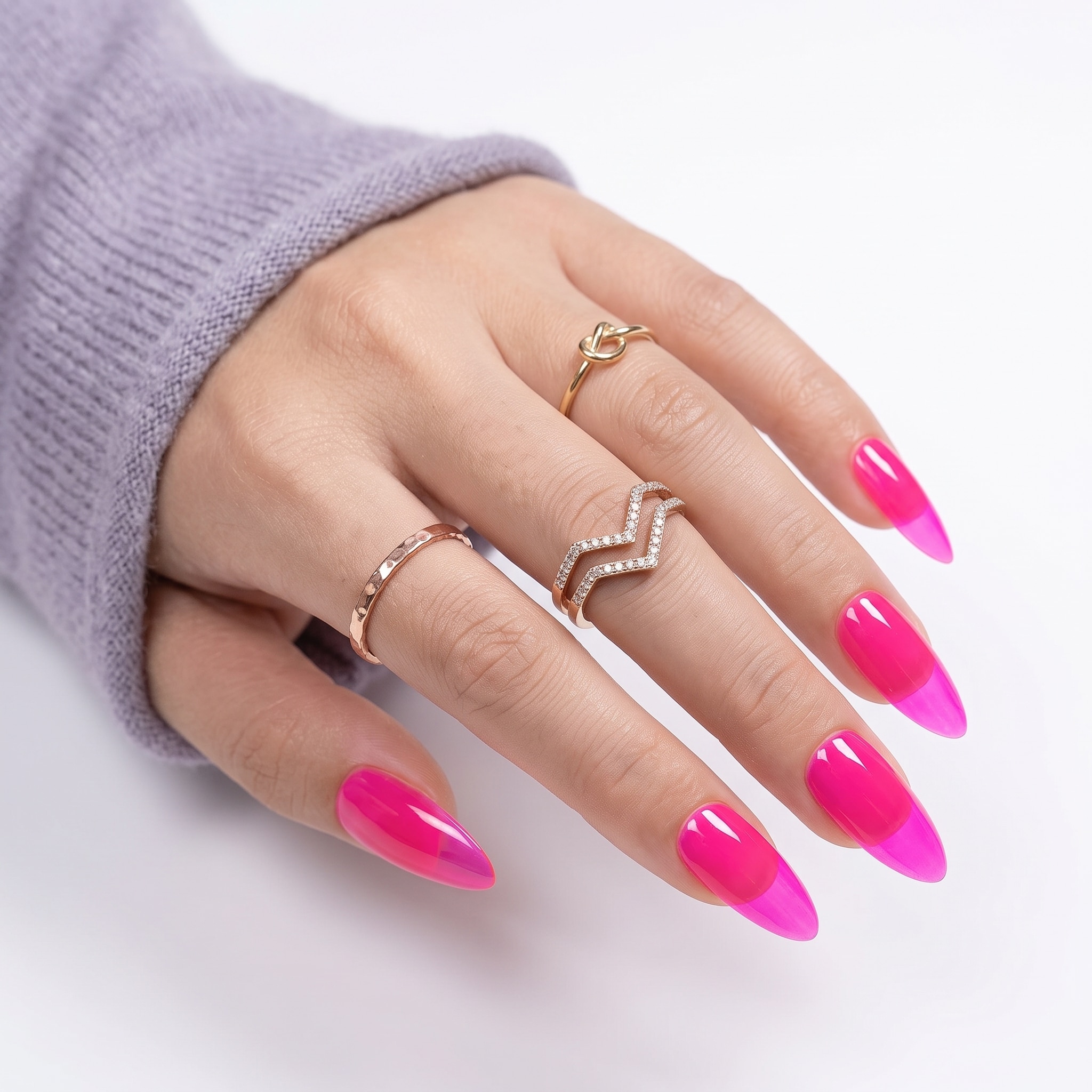 Long glossy hot pink gel nails on a hand with thin rings