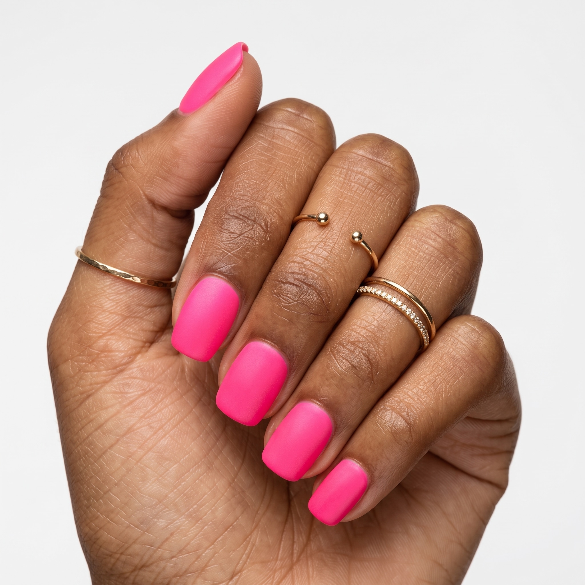 Short rounded nails painted with glossy hot pink gel polish