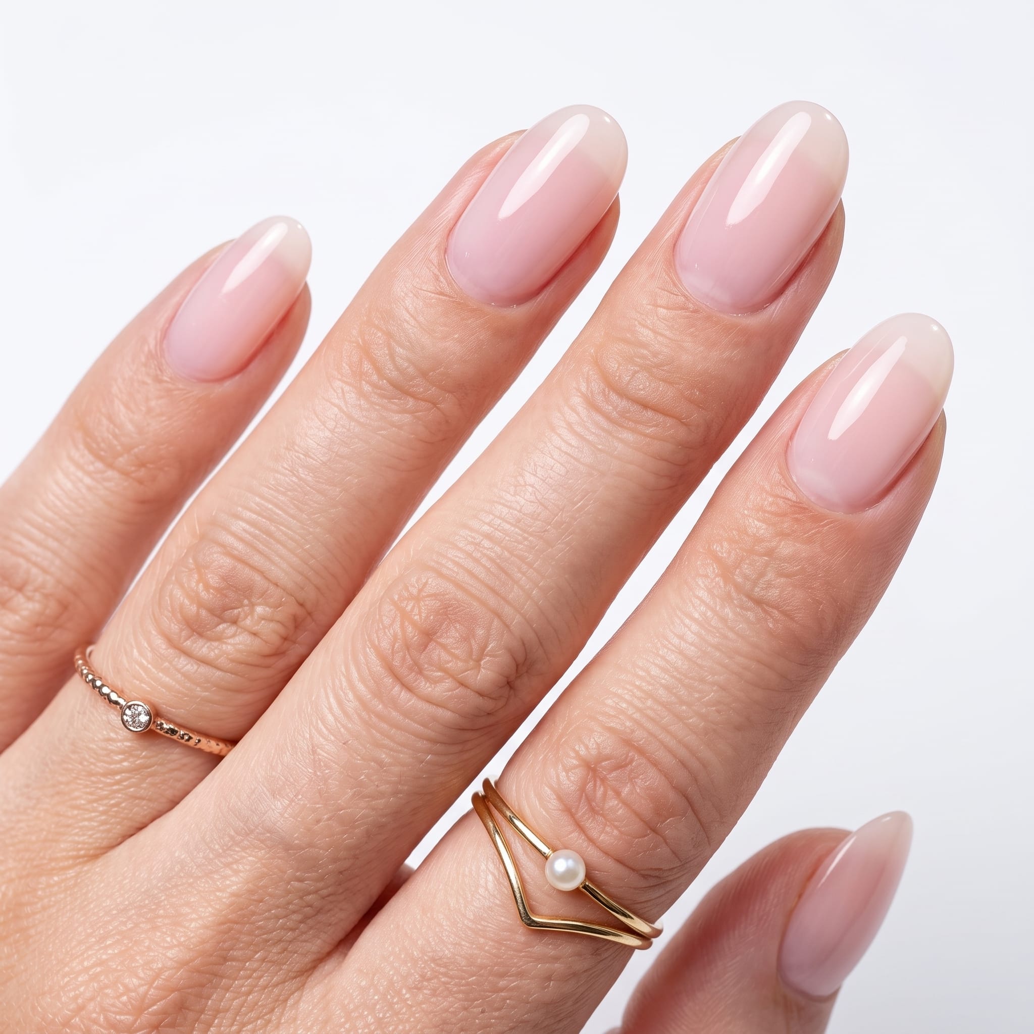 Soft pale pink nails on brown skin with a glossy natural finish