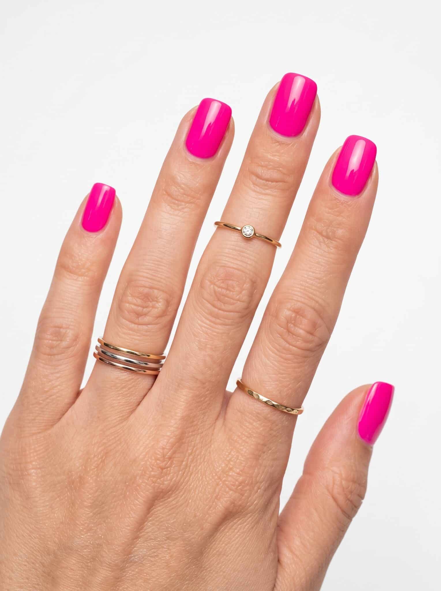 Neon pink nails with fine glitter accents