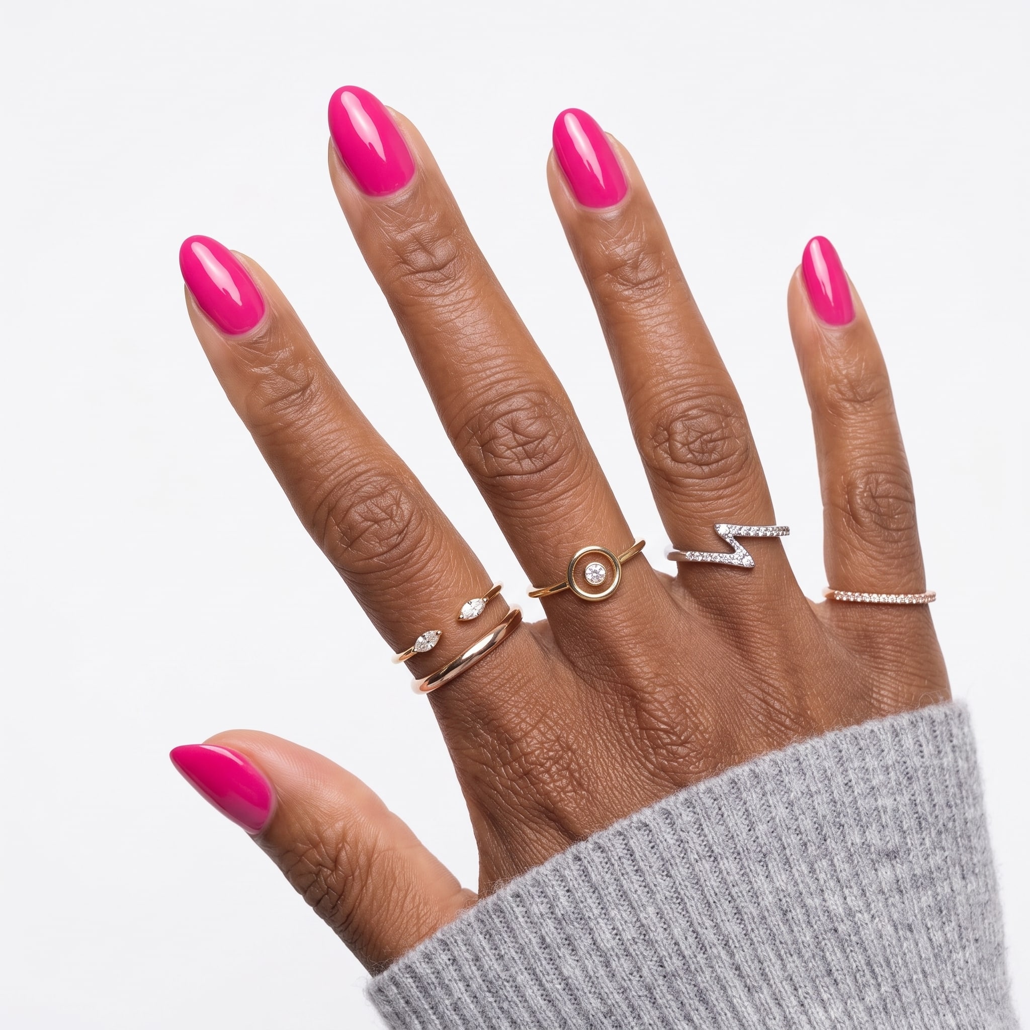 Bright pink almond nails with a soft beige knit sleeve