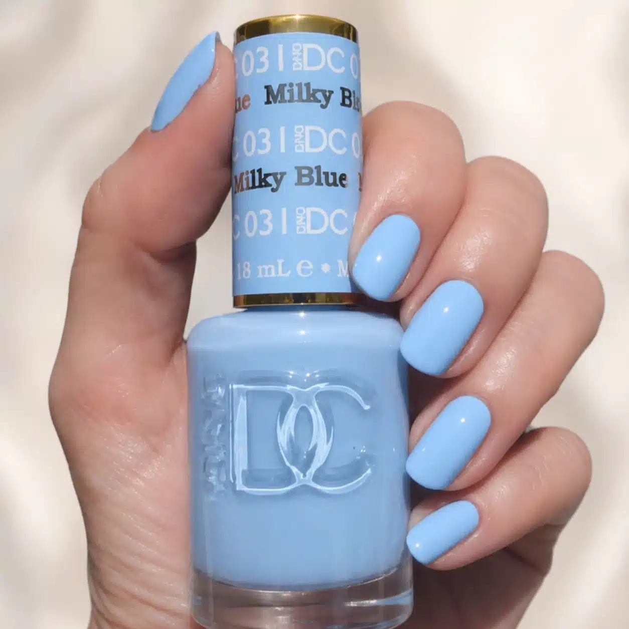 Milky Blue Nail Polish: 10 Soft Manicure Ideas to Try 9 Milky blue polish bottle beside matching manicure