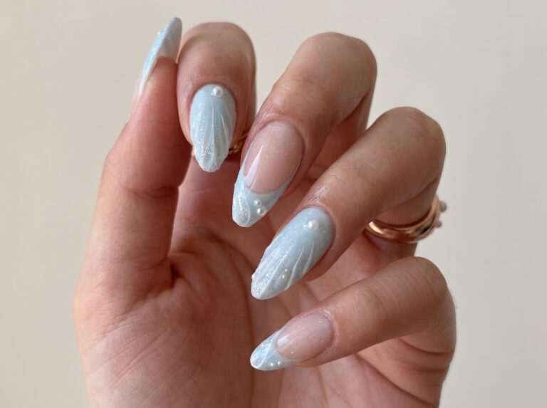 beachside manicure with clear sculpted tips and mixed seaside treasures
