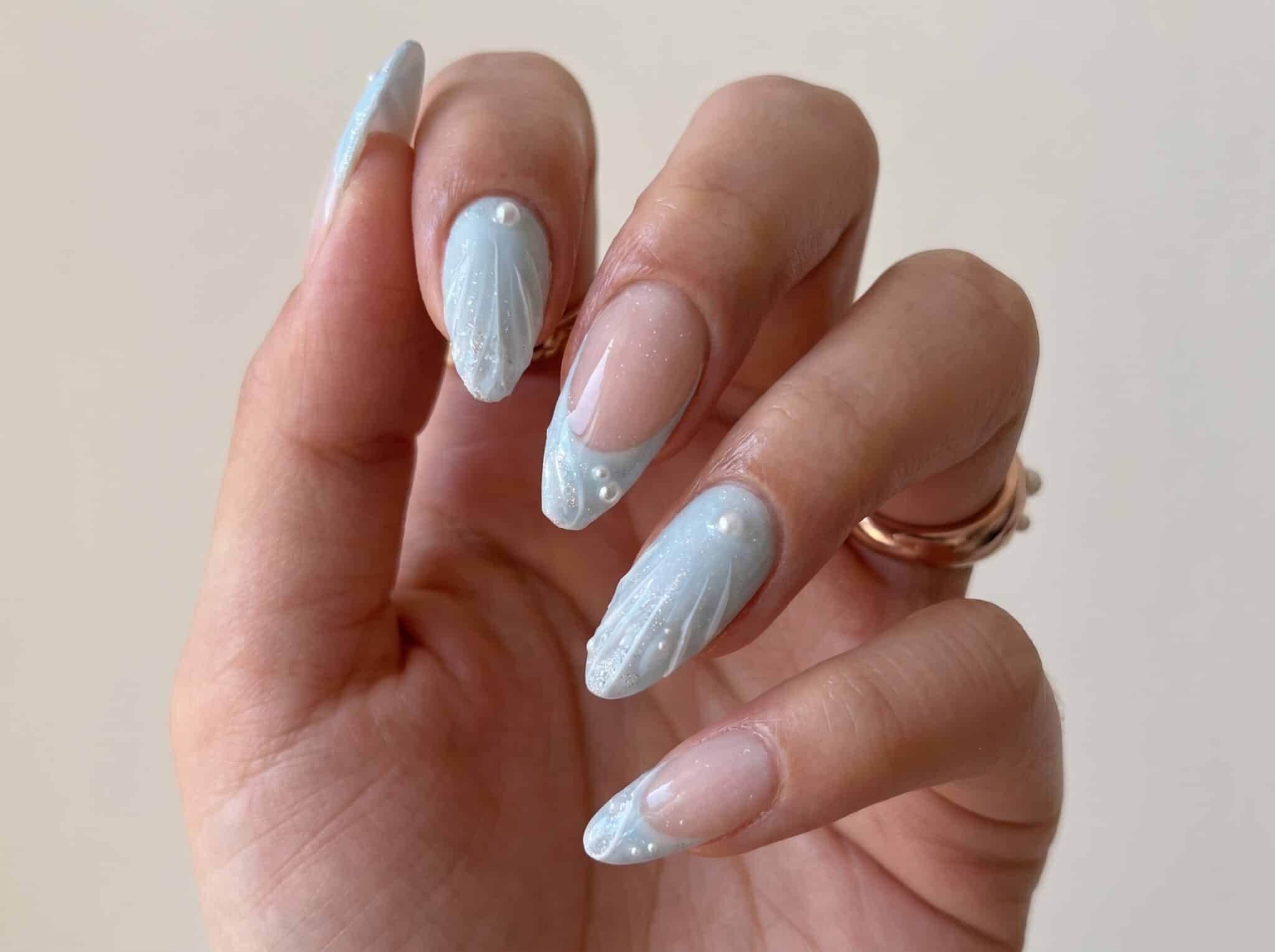 beachside manicure with clear sculpted tips and mixed seaside treasures