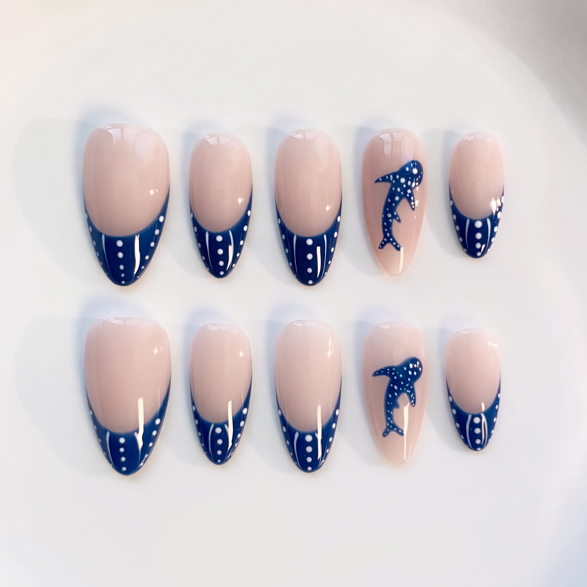 blue spotted ocean manicure with nude base and shark-inspired tips
