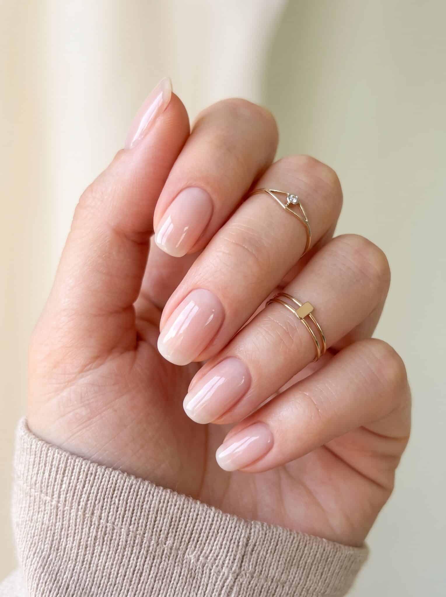 Sheer pink gel nail polish on clean glossy almond nails