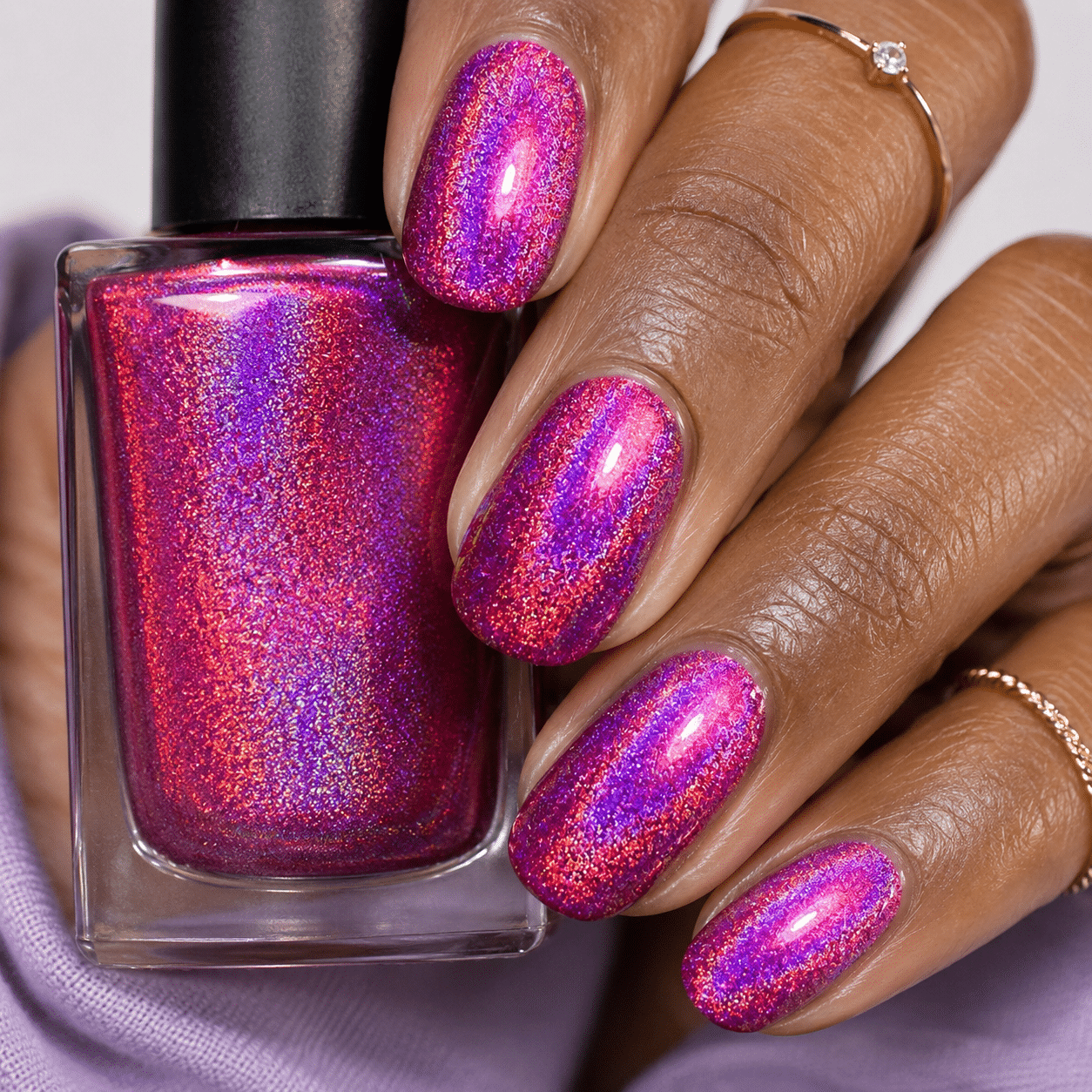 Magenta holographic nails with a bold rainbow polish effect