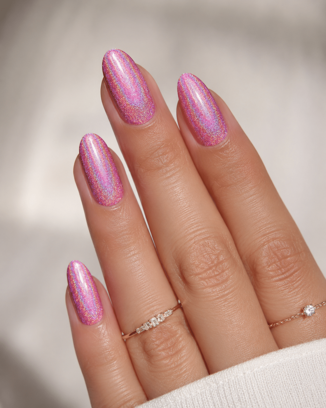 Pastel pink holographic nails with a soft rainbow sparkle