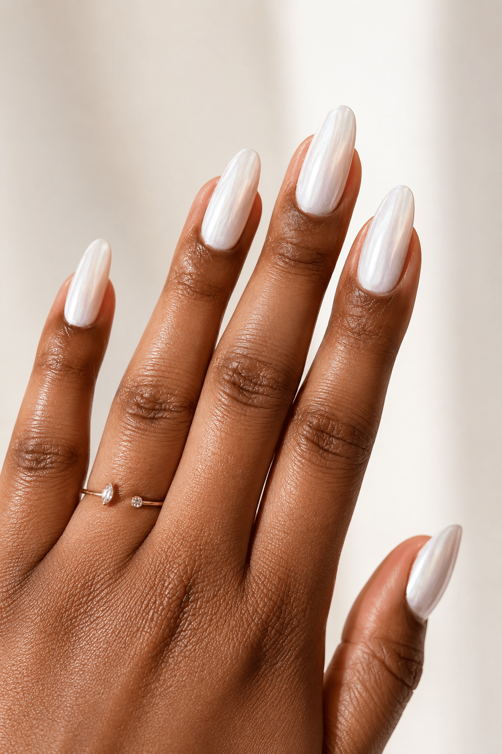 pearl white nail polish on deep skin tone with glossy luminous finish