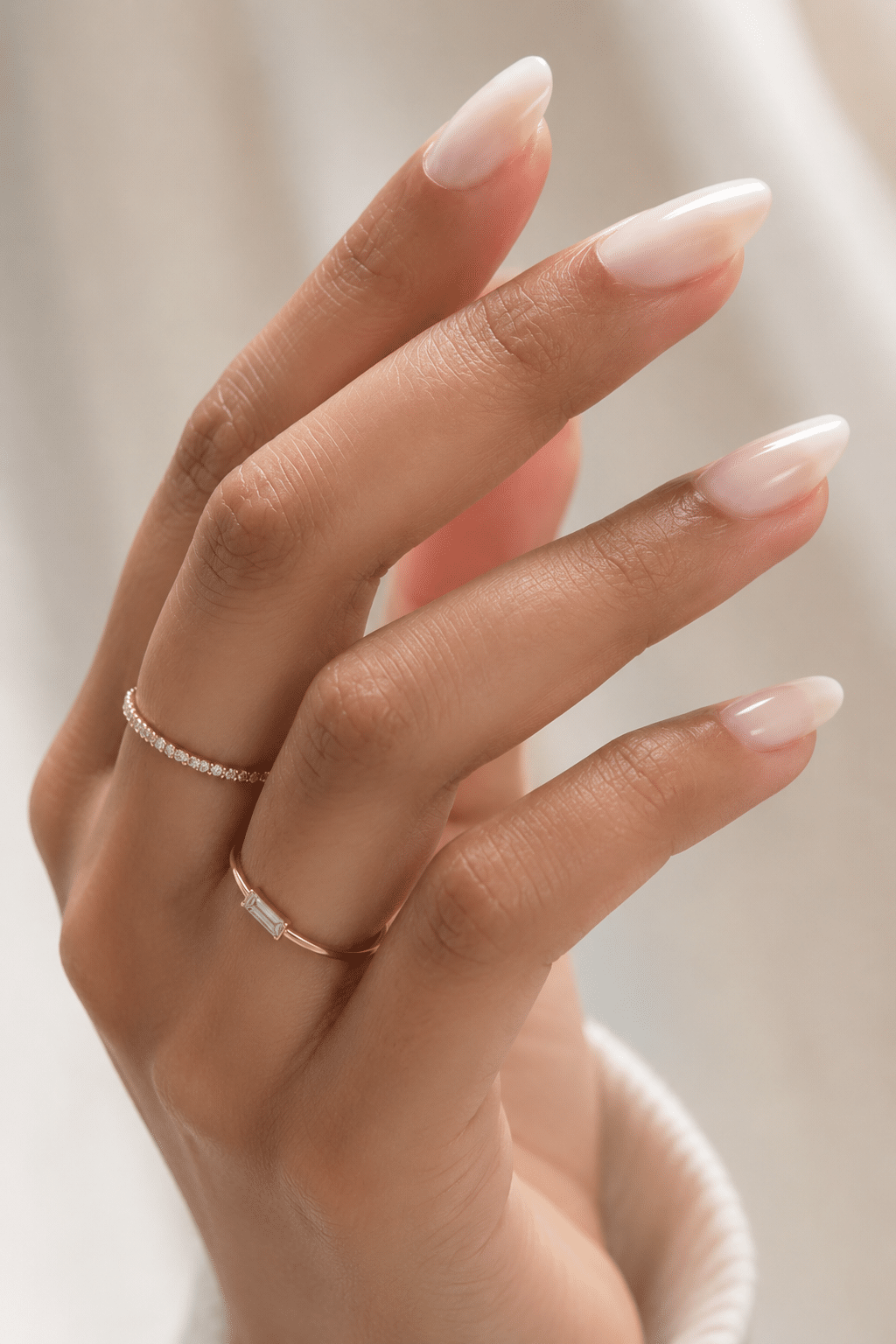 Sheer white almond nail polish with glossy translucent manicure finish