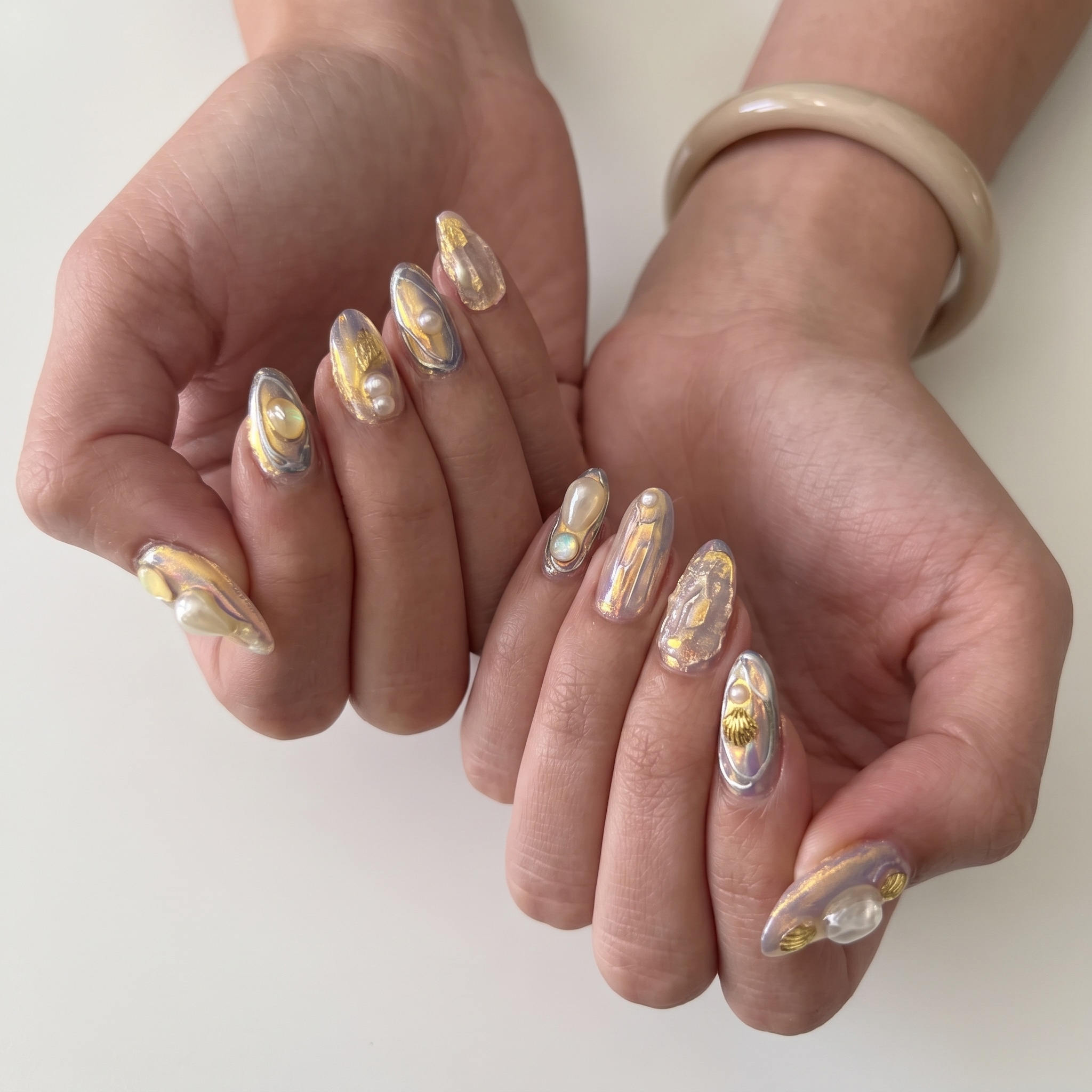 shell shock manicure with coral pink sculpted tips and glossy beach texture