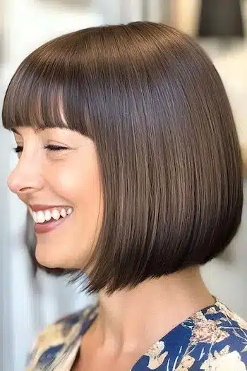 Blunt bob with straight bangs on a smiling woman