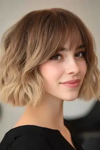 Tousled wavy blunt bob with bangs on a smiling woman