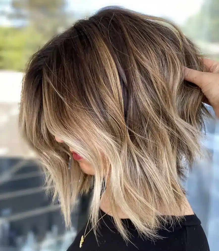 Angled balayage bob with sun-kissed highlights, one of the 35 short brown hairstyles you'll be seeing everywhere
