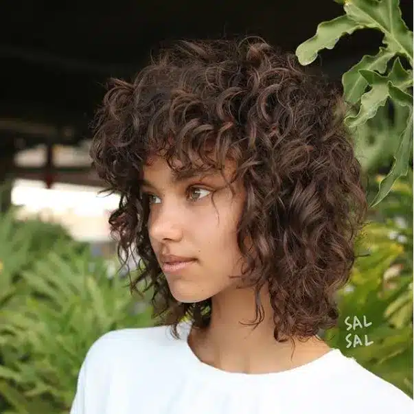 Curly shag with feathered fringe, one of the 35 short brown hairstyles you'll be seeing everywhere