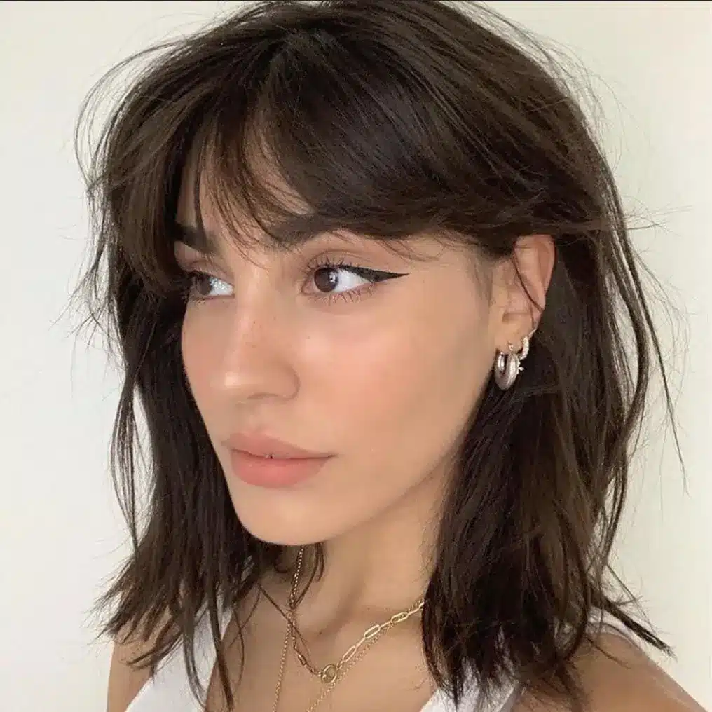 Wispy curtain bangs paired with a short cut, among the 35 short brown hairstyles you'll be seeing everywhere