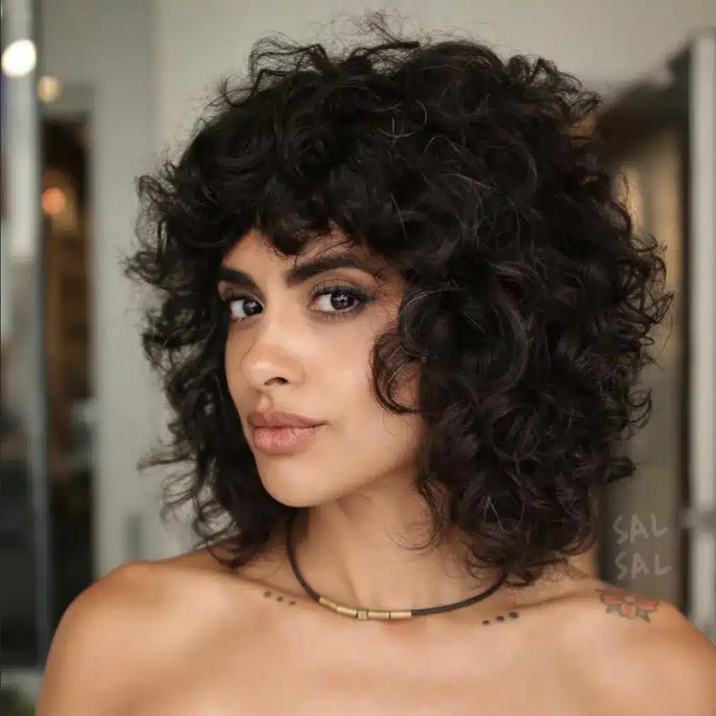 Retro curly bangs styled with volume, featured in the 35 short brown hairstyles you'll be seeing everywhere